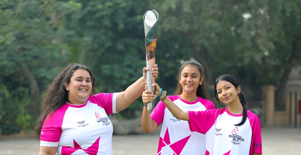 Girls in Pakistan holding the Queen's Baton as part of the international Queen's Baton Relay